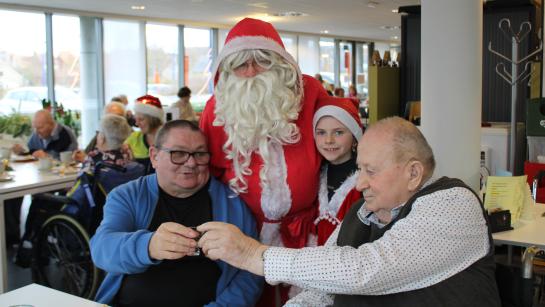 Twee bewoners van het WZC klinken samen met de kerstman op de kersperiode