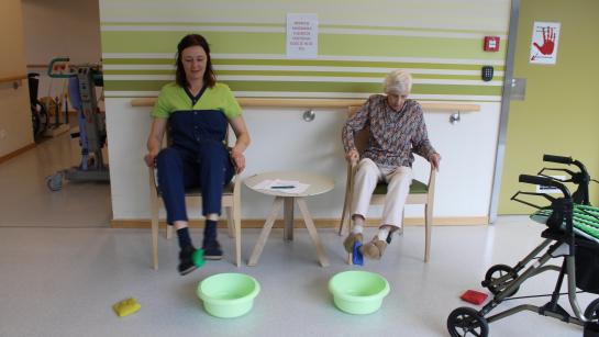 Een bewoner en medewerker doen samen een oefening in week van de valpreventie
