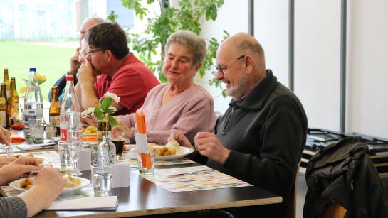 Enkele dorpsgenoten genieten van een maaltijd in het dorpsrestaurant