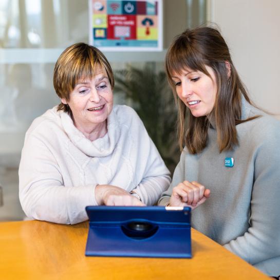 Een vrijwilliger van de digibank helpt een burger met digitale vragen